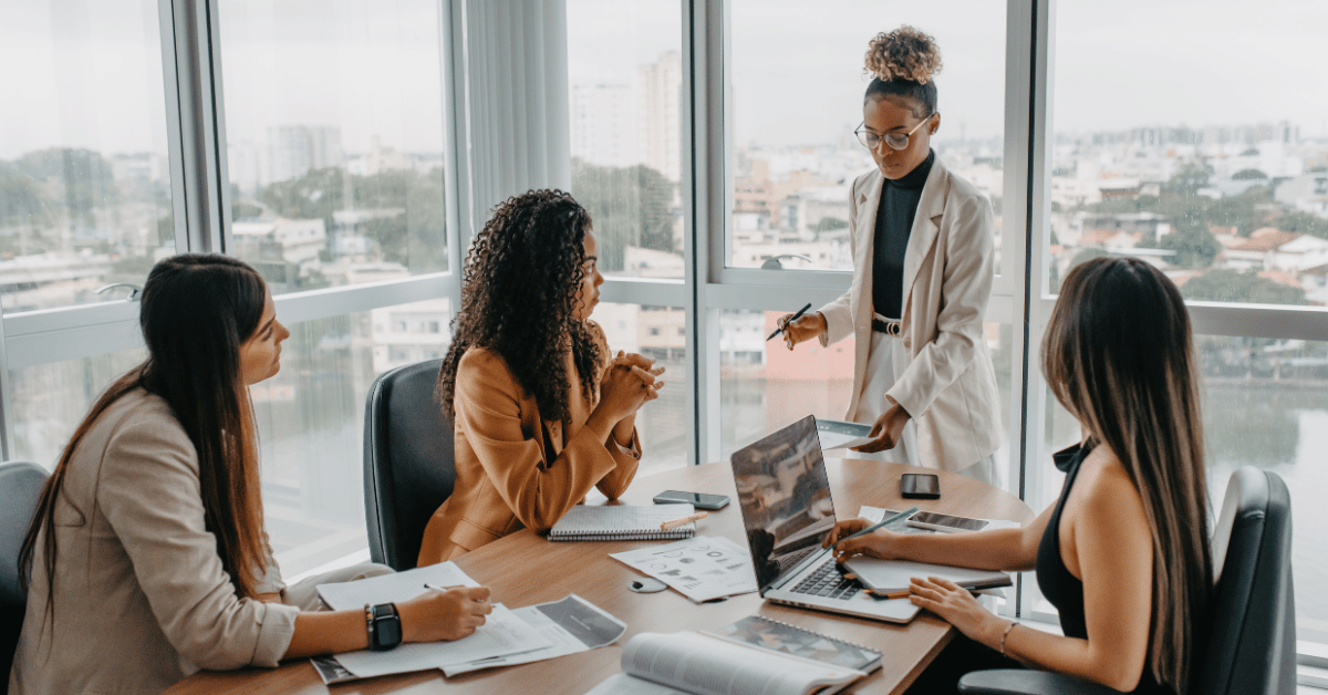 Woman leading a marketing strategy meeting with her team in a collaborative office setting, discussing direction and decision-making for business growth.